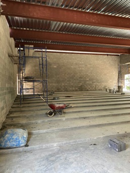 Thumbnail photo of the interior of Library's new Community Room addition under construction, showing the tiered concrete floor.